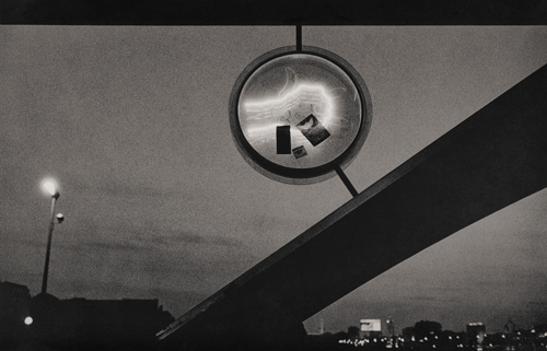 Street sign illuminated at night on a bridge in Berlin.