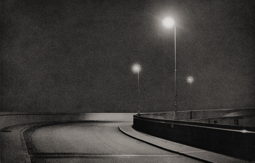 Three street lights at night illuminating a road bridge in Norway